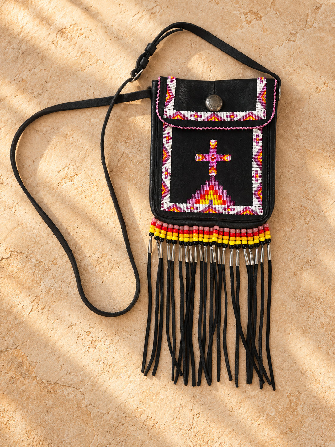 Black shoulder bag by Fabian Fontenelle with colorful hand-beaded designs, traditional glass crow beads, silver cones, and long black fringe